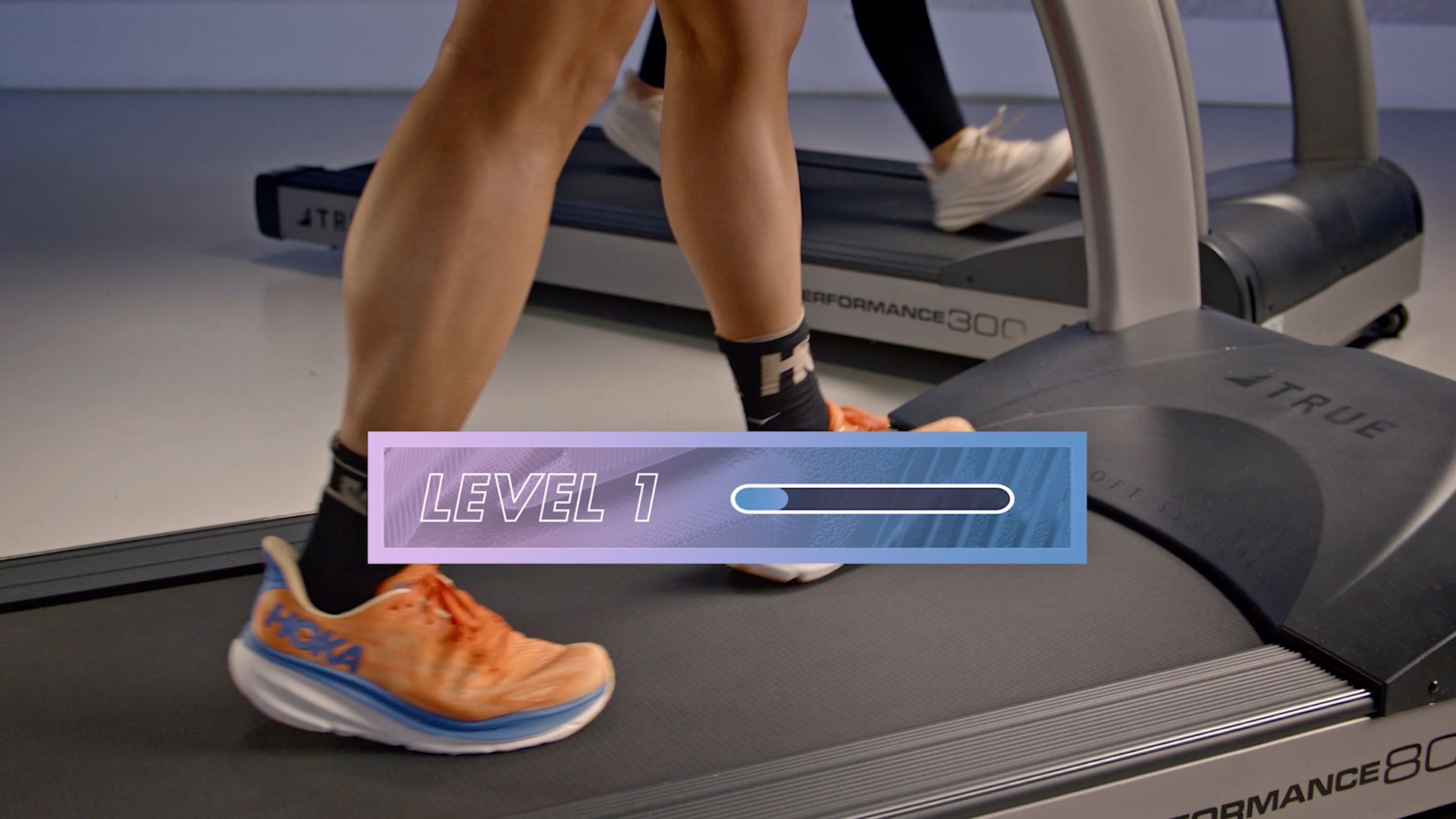 Close-up of legs wearing orange HOKA running shoes walking on a treadmill with a graphic overlay showing a progress bar labeled Level 1.