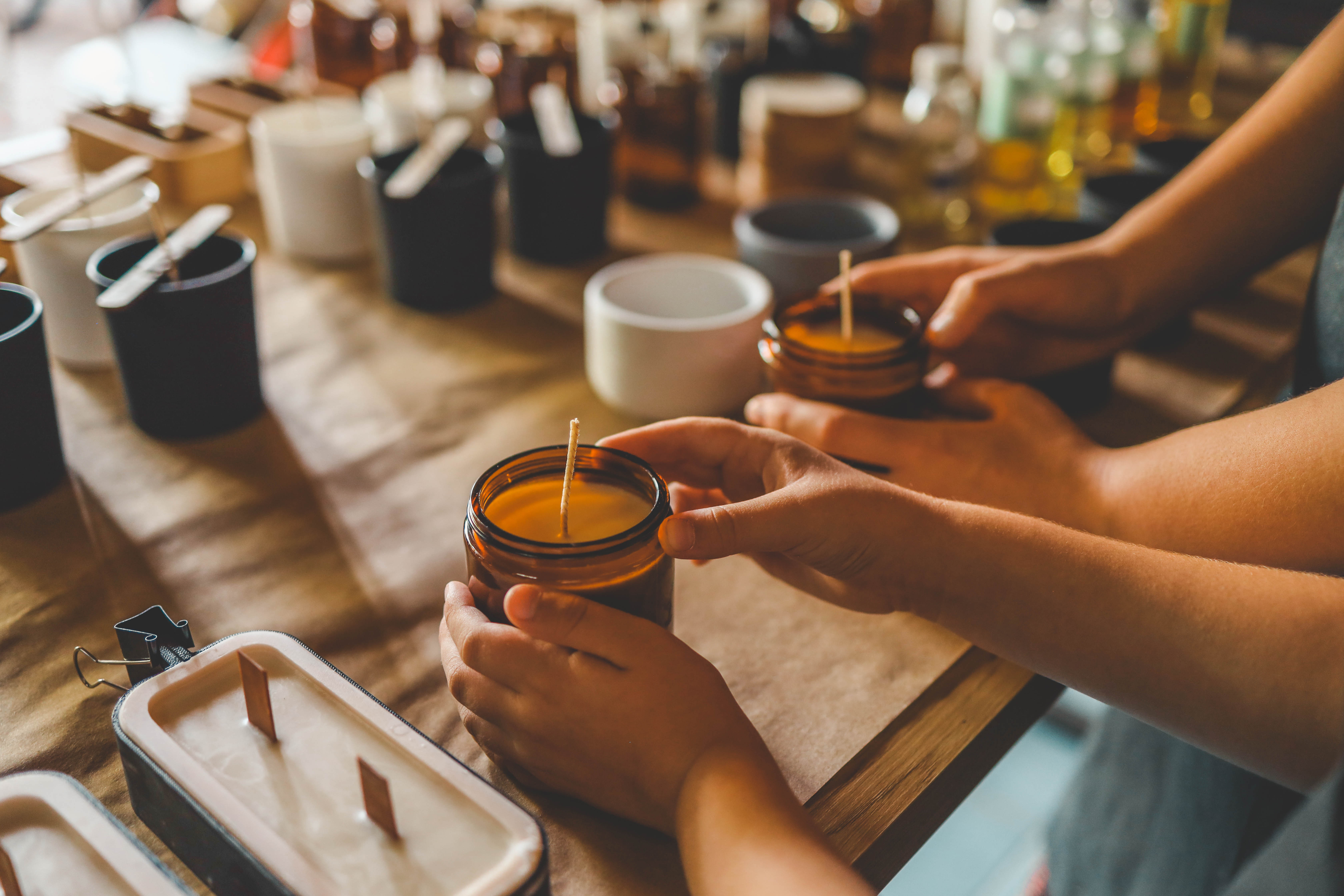 Cut-and-sew factory materials including fabric rolls, thread spools, and tailoring scissors on a worktable, representing textile manufacturing and fabric sourcing.