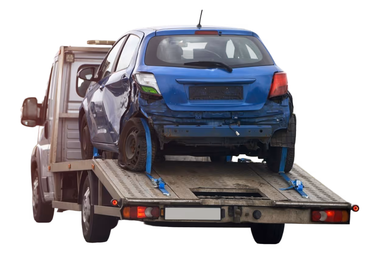 Damaged blue hatchback car secured on the flatbed of a towing truck.