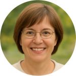 Smiling woman with light brown hair and glasses against a blurred green background.