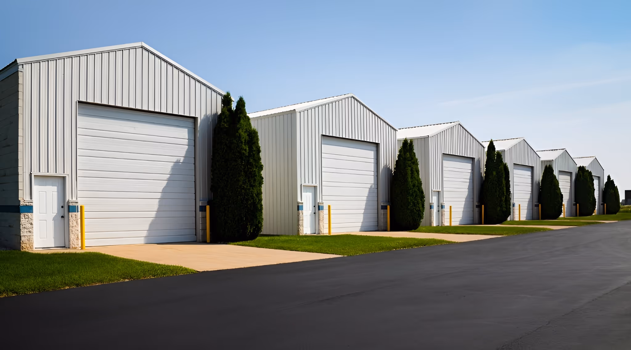 a row of industrial-style buildings with large metal garage doors.