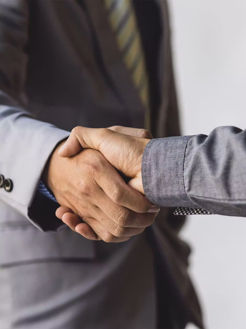 Handschlag in Business-Anzügen, Symbol für Partnerschaft bei der Griffin Group.