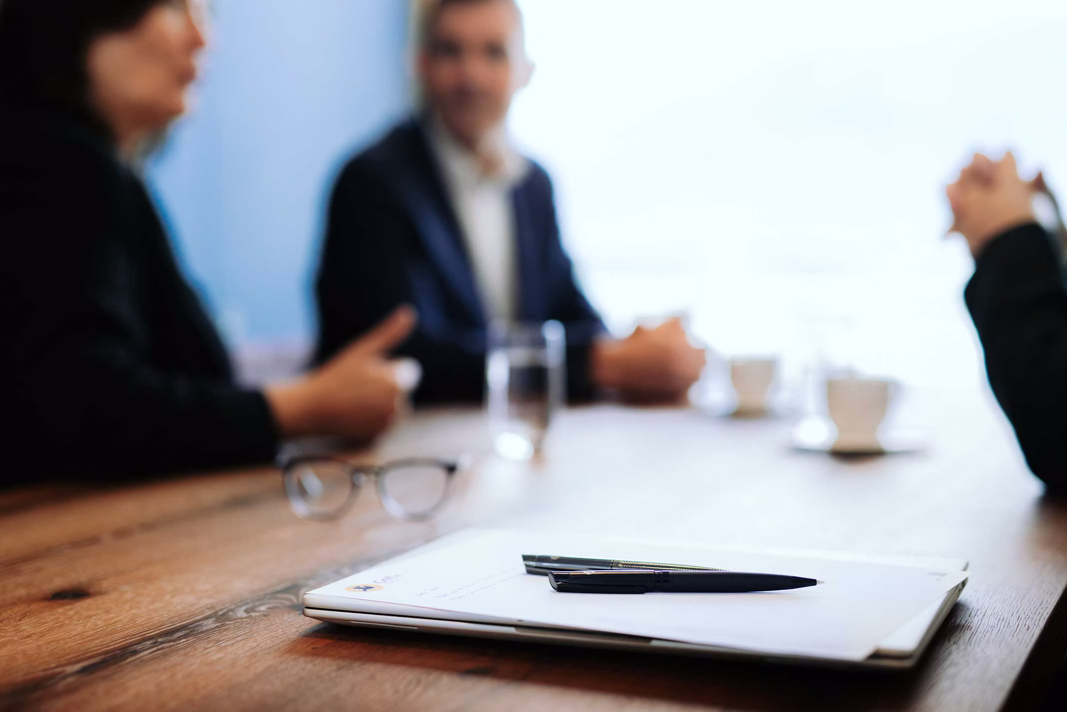 Griffin Group – Multi-Family Office: diskretes Beratungsgespräch am Konferenztisch, Unterlagen und Stift im Vordergrund.