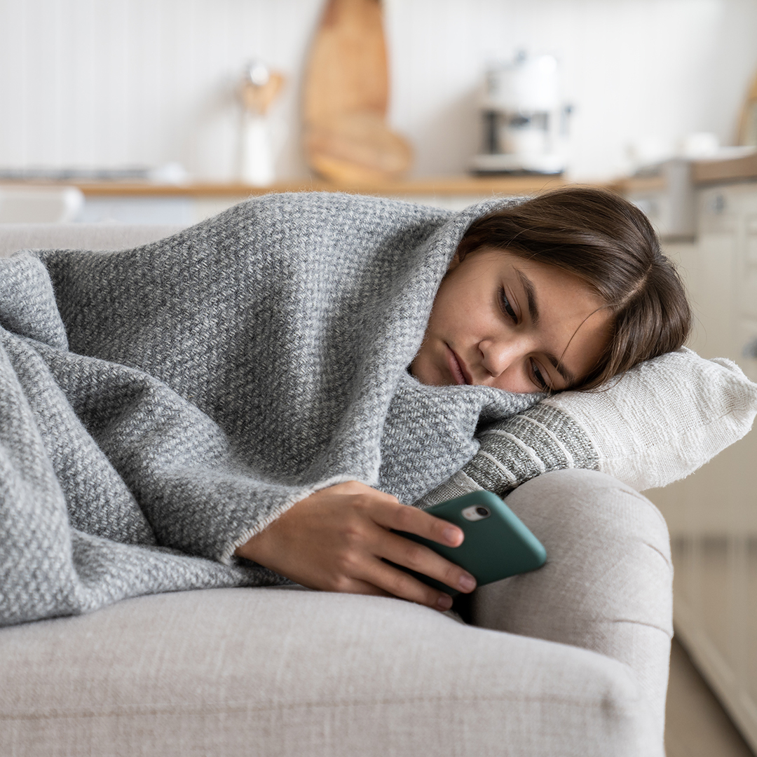 Young girl on a sofa with mental health issues and working with the SwissDTx Patient App.