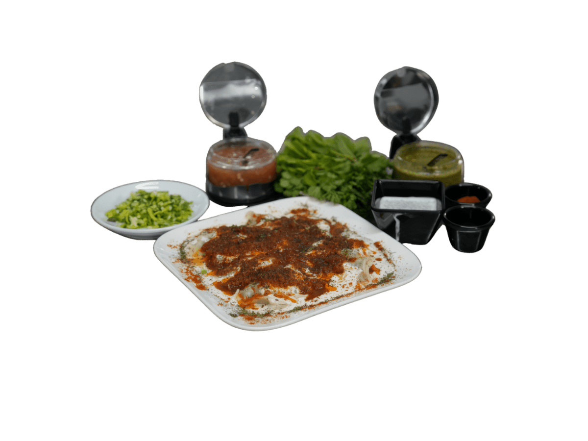 Afghanische Ashak Teigtaschen mit Lauchfüllung, Joghurt und Hackfleischsoße, serviert mit Kräutern und Dips bei Dough & More München