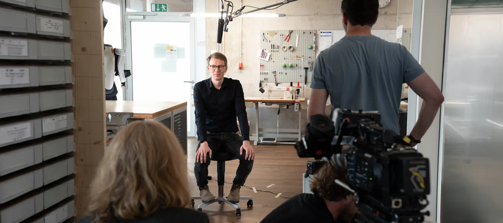 A man sitting in a chair with a camera on him.