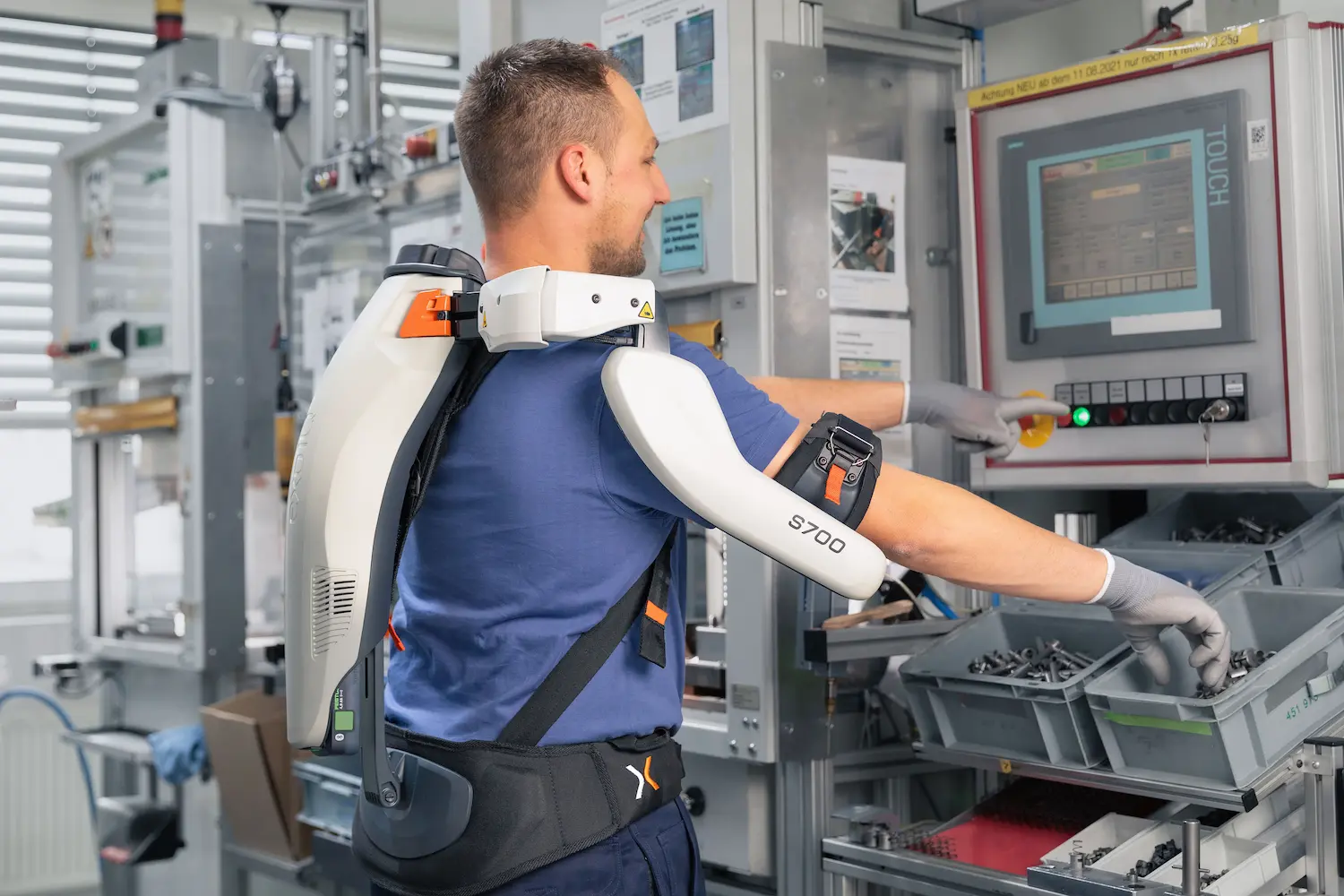 A man wearing an exoskeleton working in production.