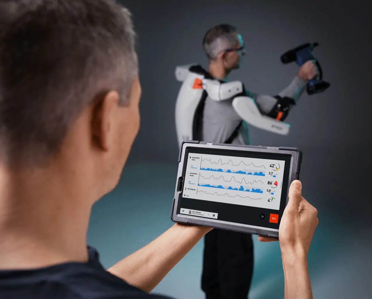 A man holding a tablet with a graph showing graphs.