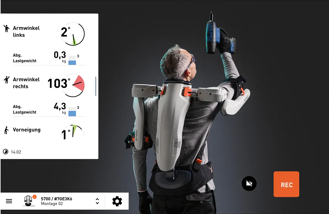 A man wearing an exoskeleton with a drill in his hand.