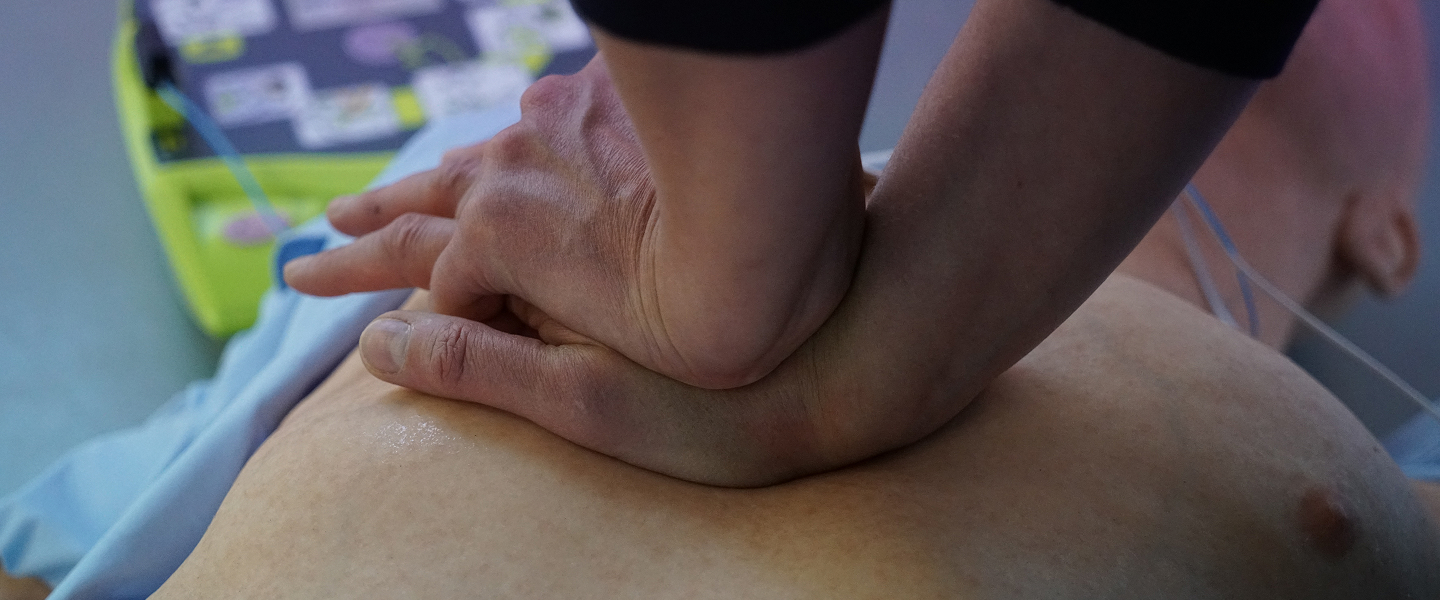 BLS training session with participants practicing CPR and AED use on a training mannequin