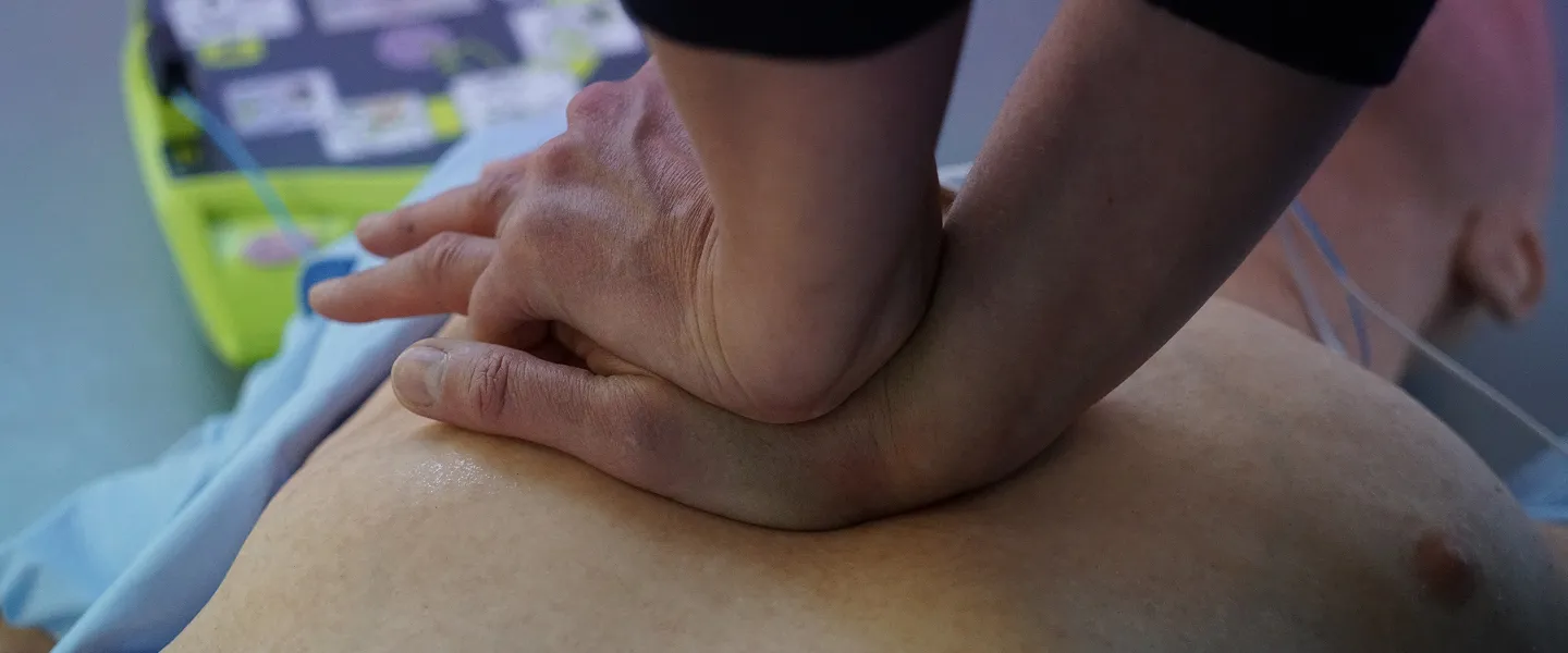 Basic Life Support training session with participants practicing CPR and AED use on a mannequin