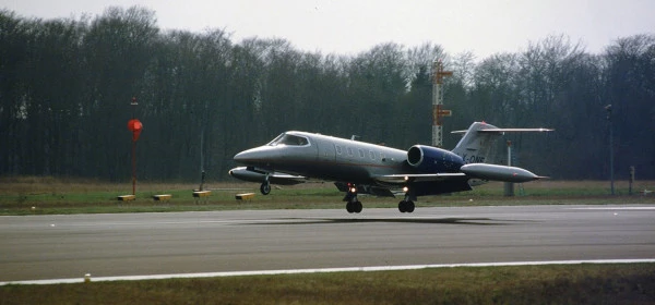 Petit jet privé atterrissant sur une piste entourée d’arbres, probablement utilisé pour des évacuations médicales.