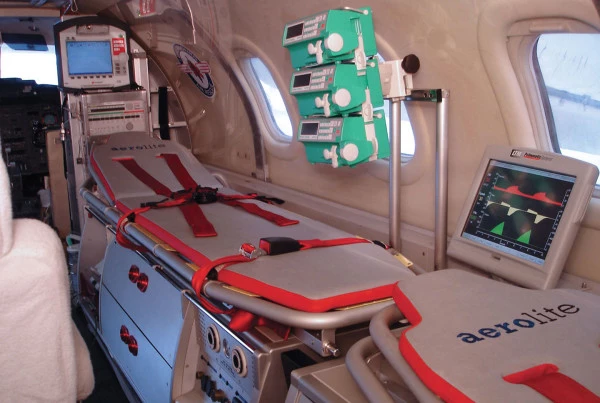 Intérieur d’un avion ambulance Luxembourg Air Rescue équipé d’une civière et de matériel médical avancé de surveillance.