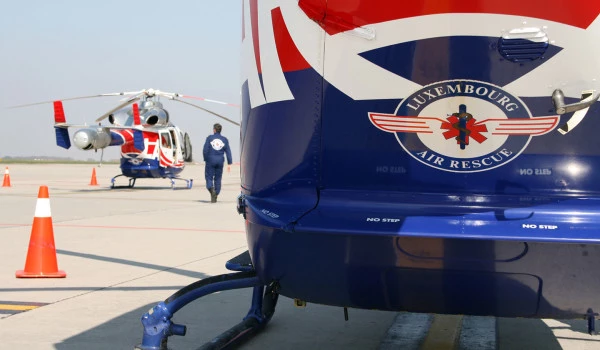 Hélicoptères Luxembourg Air Rescue sur le tarmac avec équipage en préparation d’intervention médicale d’urgence.