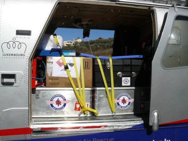 Compartiment de chargement d’un hélicoptère Luxembourg Air Rescue avec matériel médical et humanitaire sécurisé.