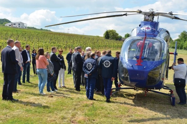 Démonstration d’un hélicoptère Luxembourg Air Rescue en milieu rural avec équipe et visiteurs observant les capacités de secours.