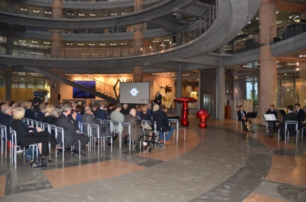 Conférence ou cérémonie Luxembourg Air Rescue dans un bâtiment moderne avec public et présentation sur l’aviation médicale.