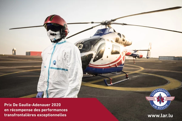 Hélicoptère Luxembourg Air Rescue avec pilote en tenue de protection, illustrant les interventions transfrontalières primées (Prix De Gaulle-Adenauer 2020).