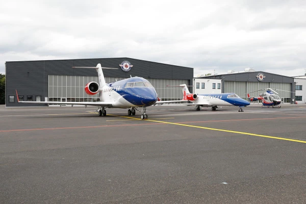 Flotte Luxembourg Air Rescue composée de jets et hélicoptères stationnés devant la base, illustrant les capacités de secours aérien.