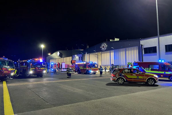 Véhicules d’urgence Luxembourg Air Rescue et pompiers rassemblés de nuit devant la base lors d’une opération coordonnée.