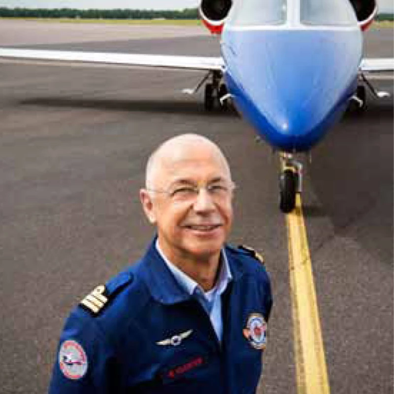 René Closter, fondateur de Luxembourg Air Rescue, devant un jet ambulance Learjet sur le tarmac.