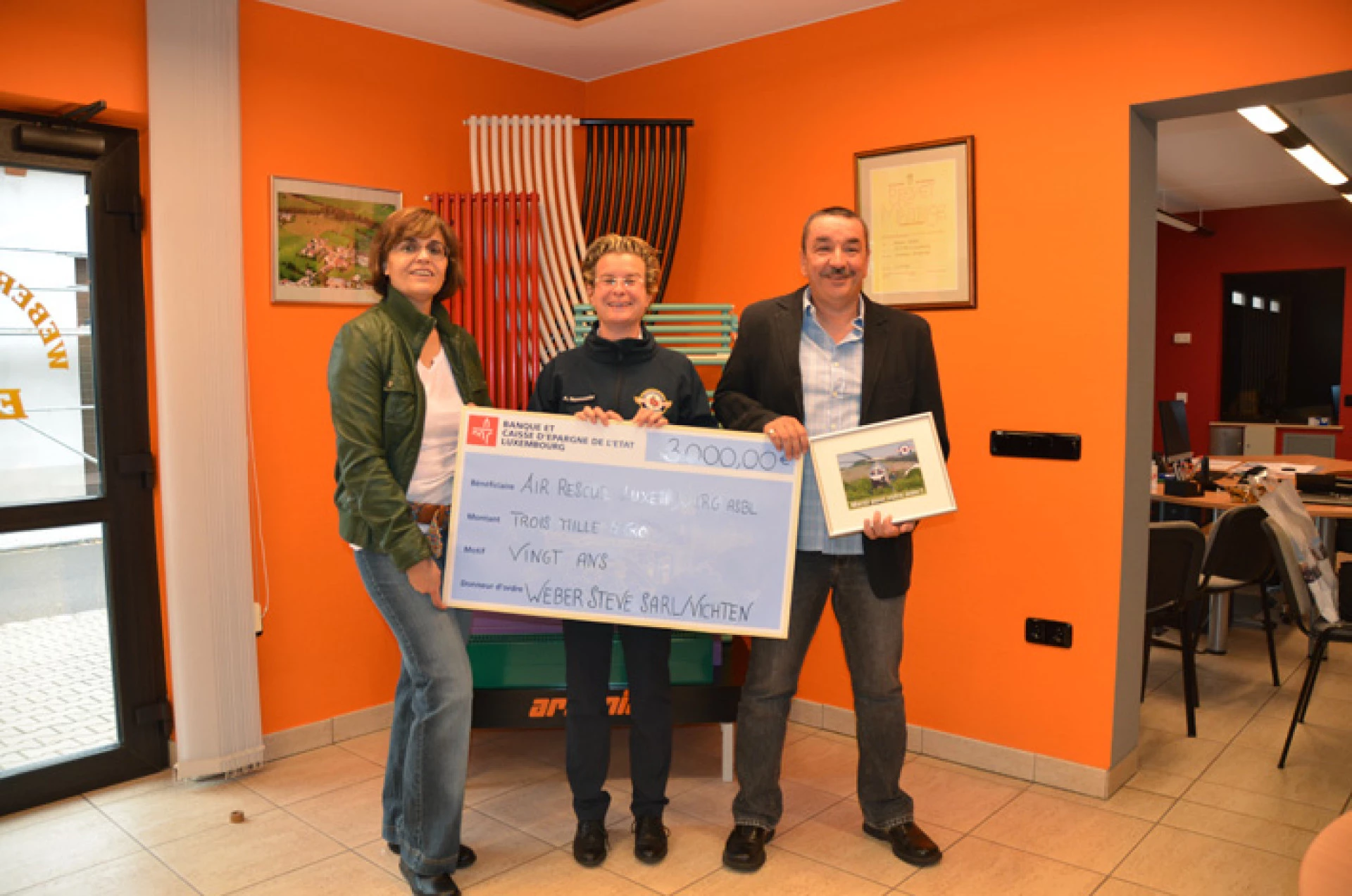 Representatives of Sanichaufer presenting a charity donation to Luxembourg Air Rescue during the company’s 20th anniversary celebration.