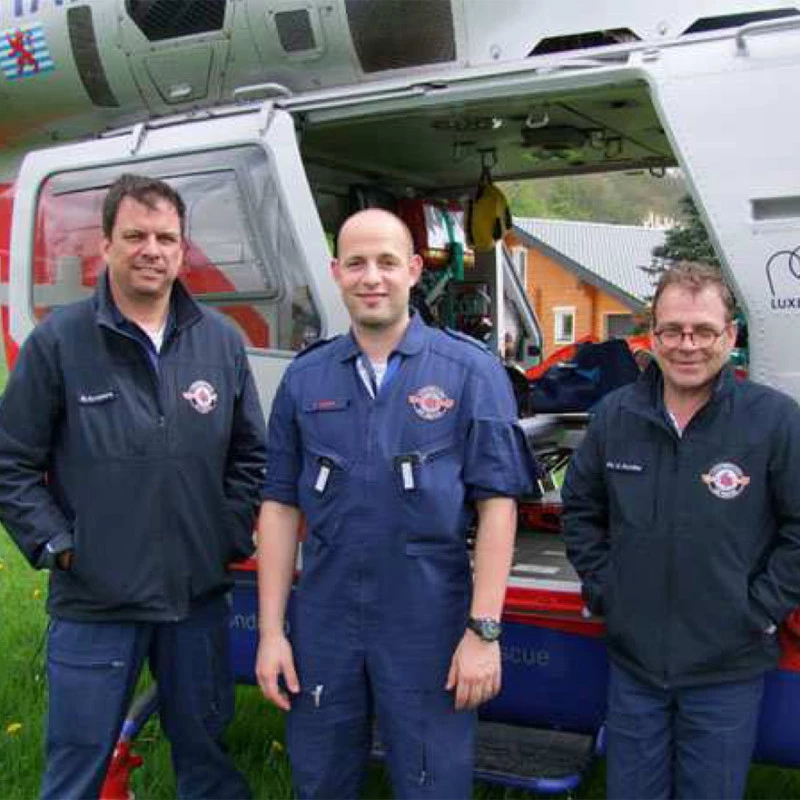 Besatzung von Luxembourg Air Rescue bereitet am Findel einen Einsatz neben einem Rettungshubschrauber vor.