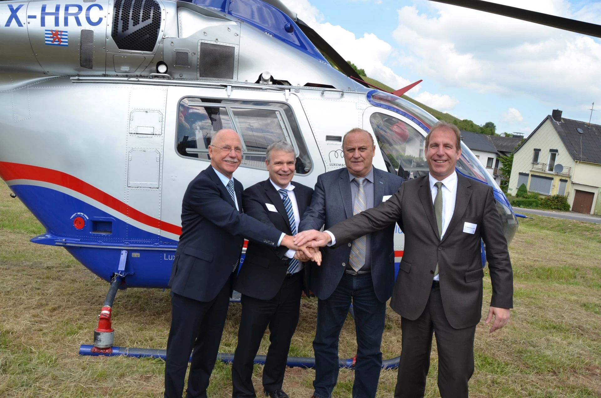 Hélicoptère de Luxembourg Air Rescue et officiels lors d’une cérémonie célébrant 10 ans de coopération transfrontalière en sauvetage aérien.