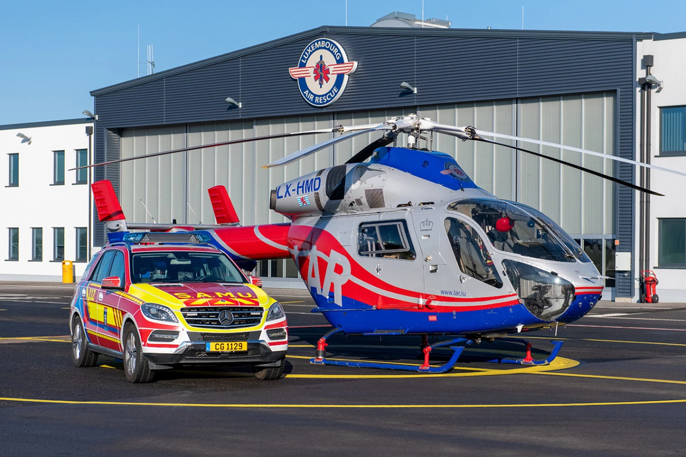 Hélicoptère de Luxembourg Air Rescue et véhicule d’intervention SAMU devant le hangar au Findel.