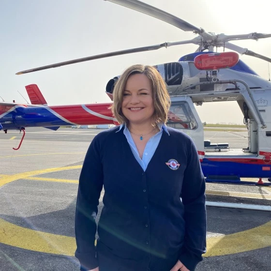 Mitarbeiterin von Luxembourg Air Rescue vor einem Rettungshubschrauber auf dem Helipad am Findel.