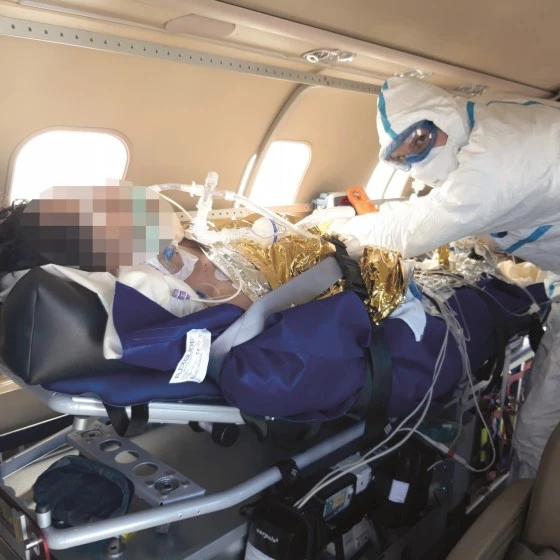 Luxembourg Air Rescue medical team caring for a COVID patient inside an air ambulance during a transfer to a European hospital.