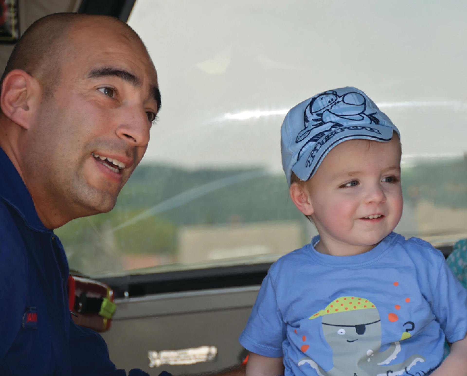 Homme souriant regardant un jeune enfant près d’une fenêtre