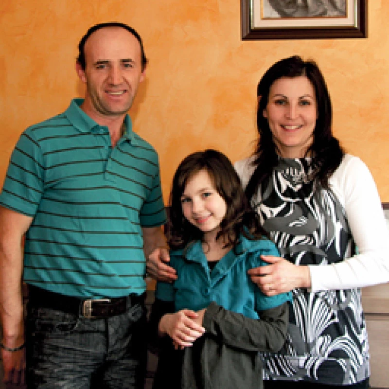 Parents debout en intérieur avec leur enfant dans un cadre familial