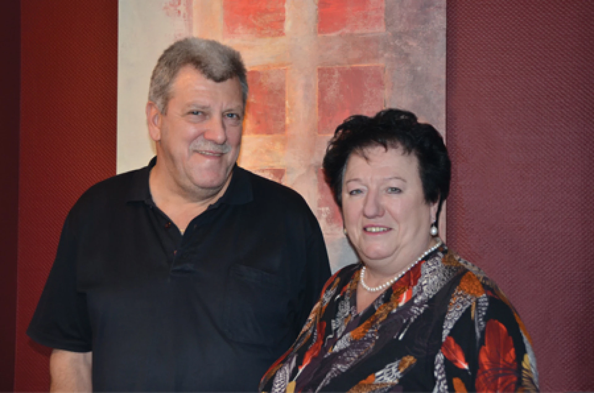 Adult couple standing indoors and smiling at the camera