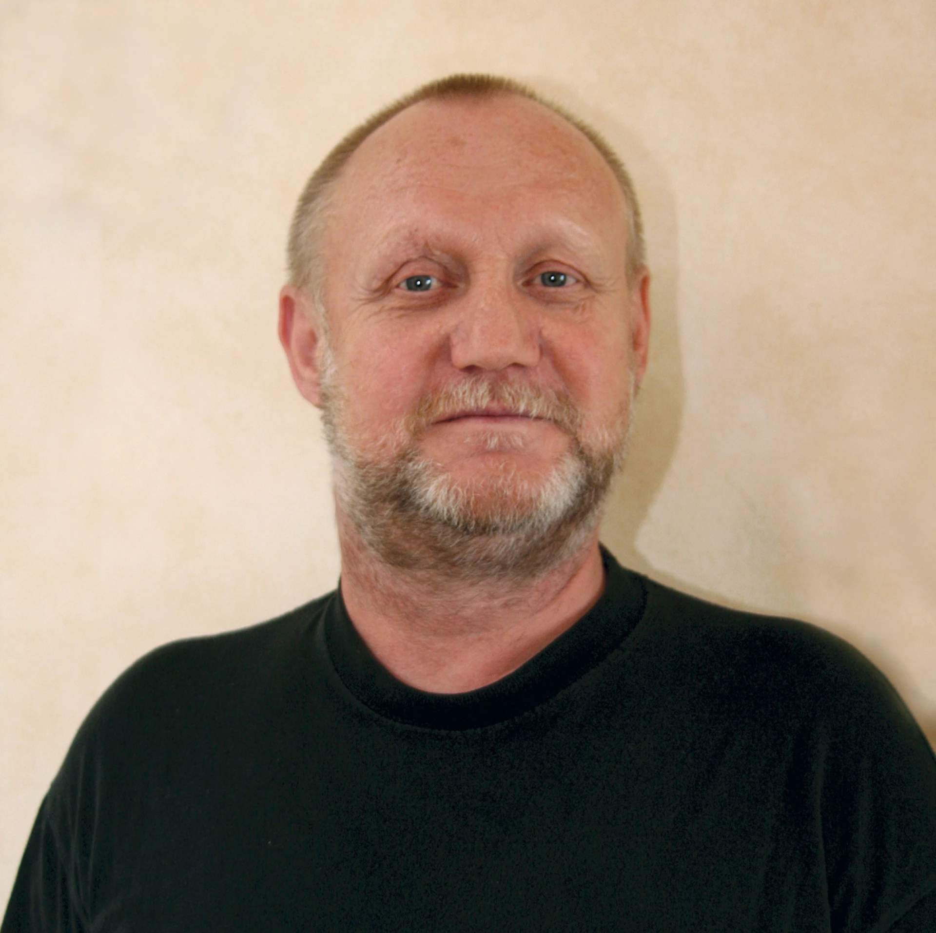 Portrait of a middle-aged man with a beard against a plain background