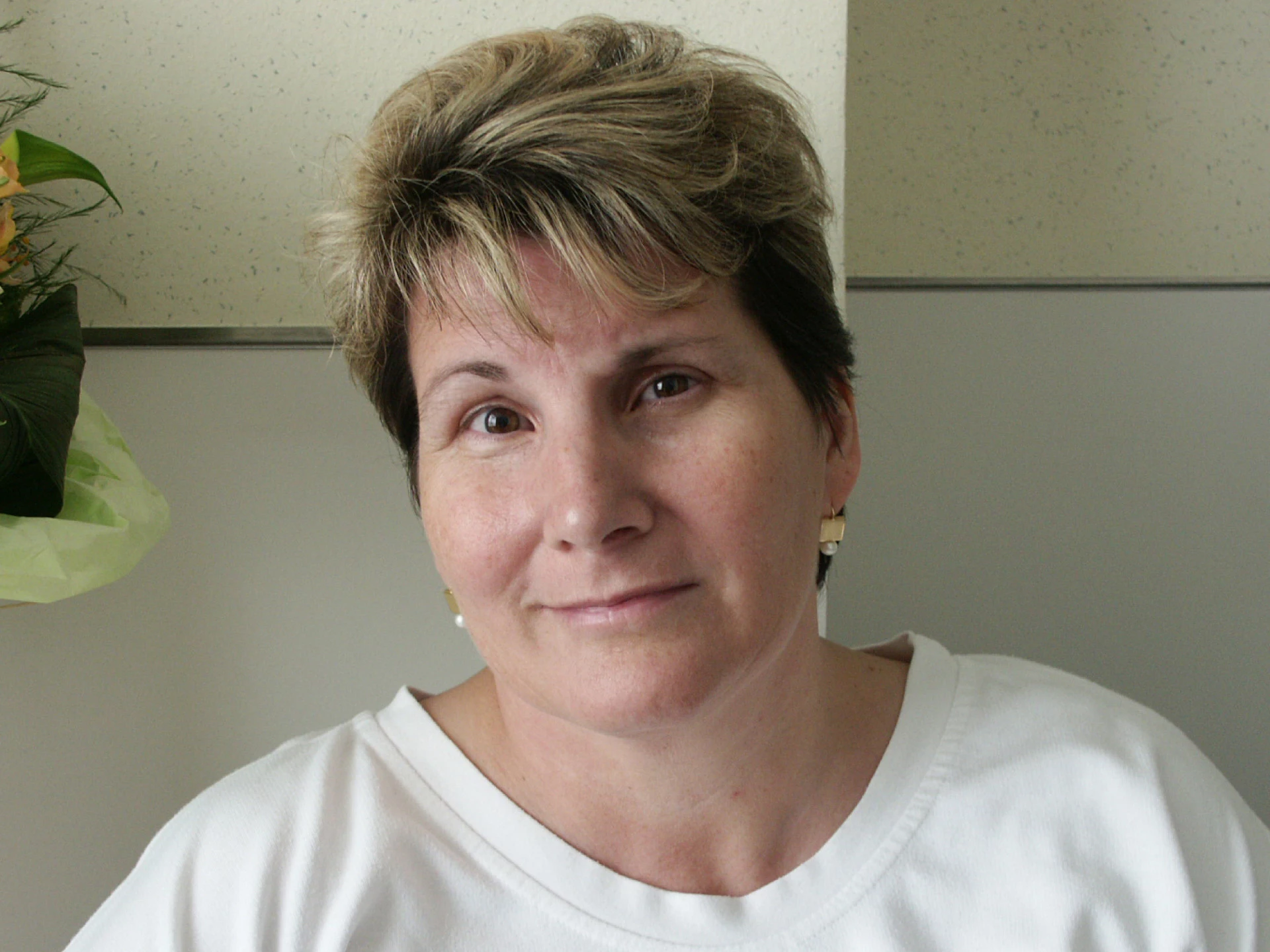 Portrait of a woman indoors with short hair and a neutral expression