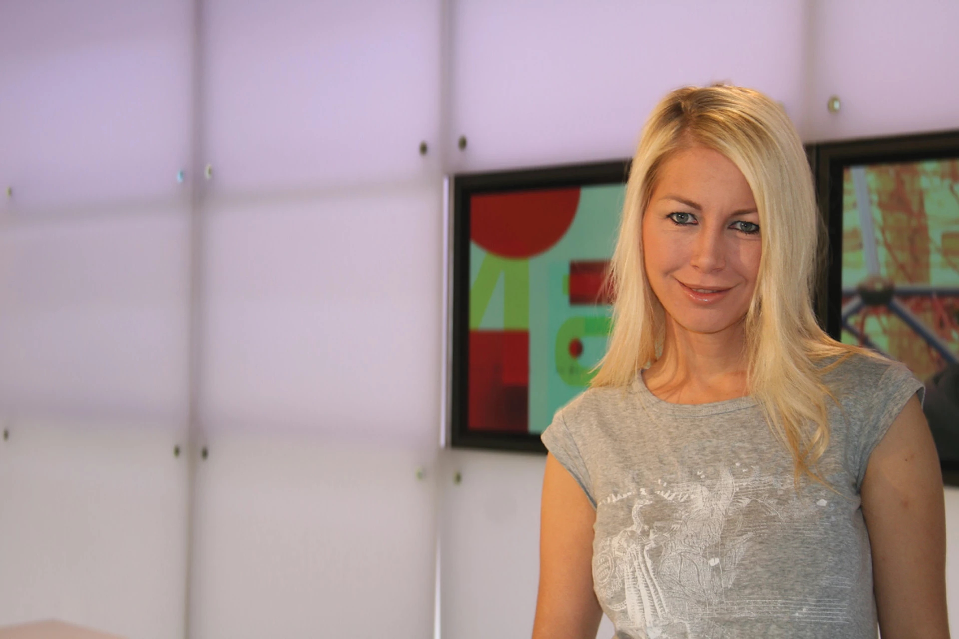 Blonde woman standing indoors in a modern office or studio environment