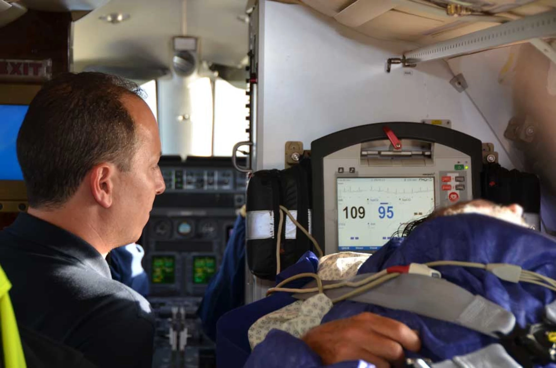 Medizinisches Personal überwacht einen Patienten in einem Ambulanzflugzeug.