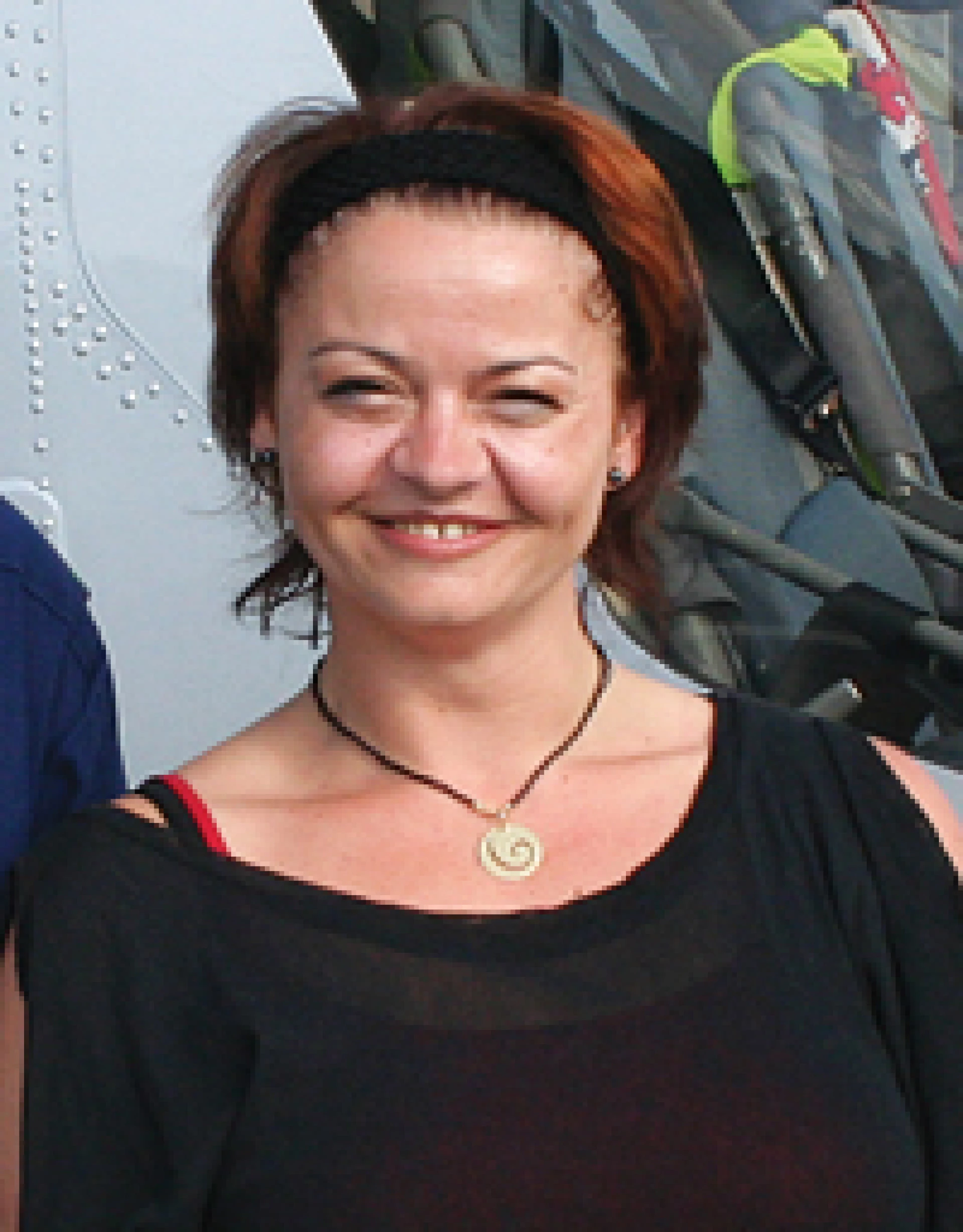 Smiling woman outdoors wearing a headband and casual clothing