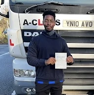 Proud new HGV driver trained by Learn2Pass standing beside training lorry in Kent.