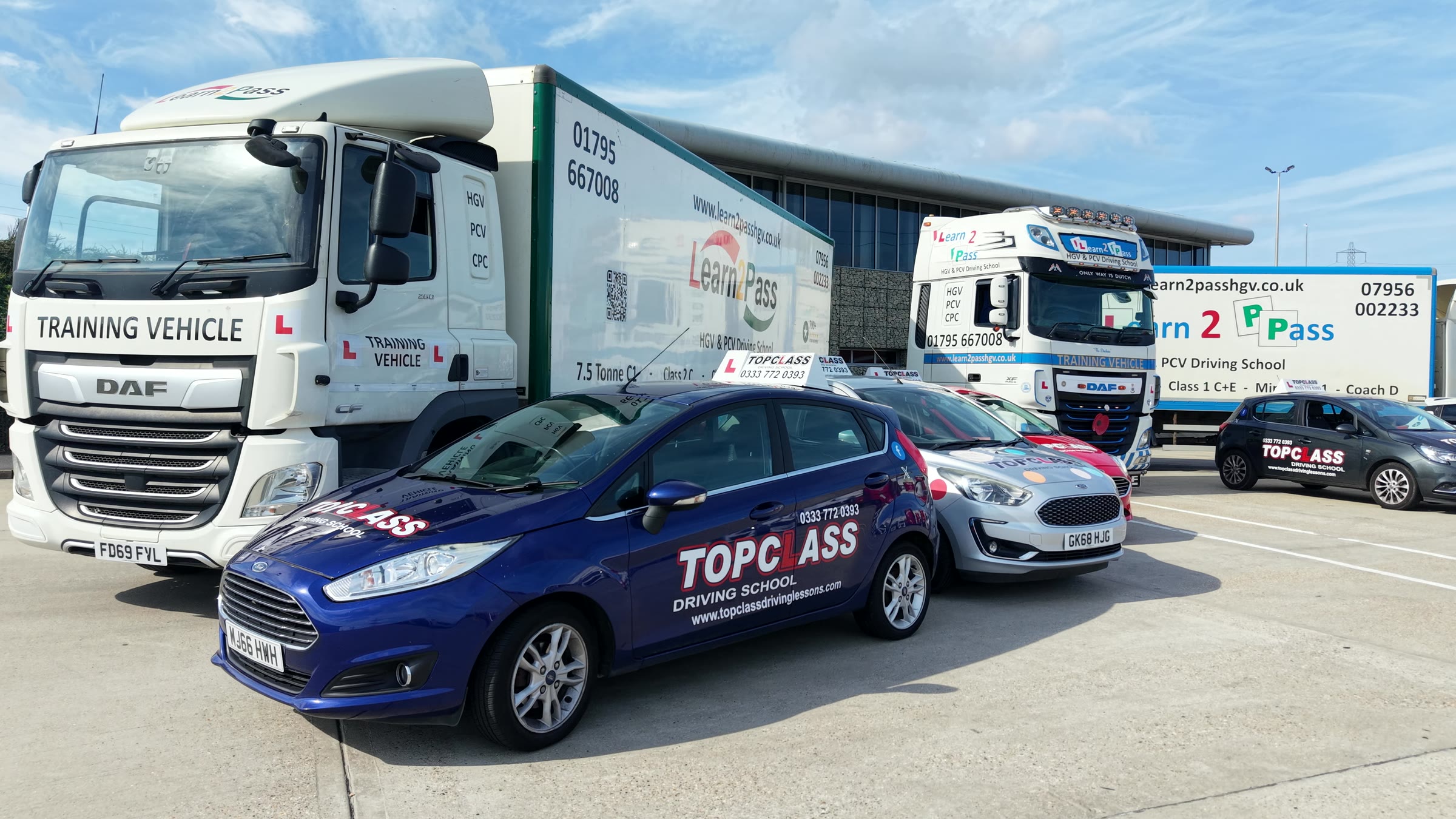 A blue Topclass car beside a Learn2Pass training lorry