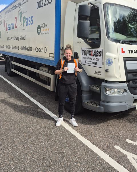 A Learn2Pass learner with a Class 2 pass certificate in front of a training lorry