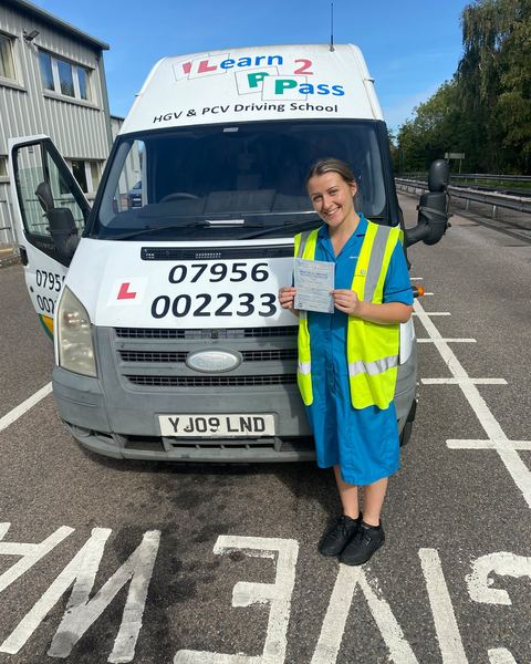 Livy with a B+E pass certificate in front of a Learn2Pass van