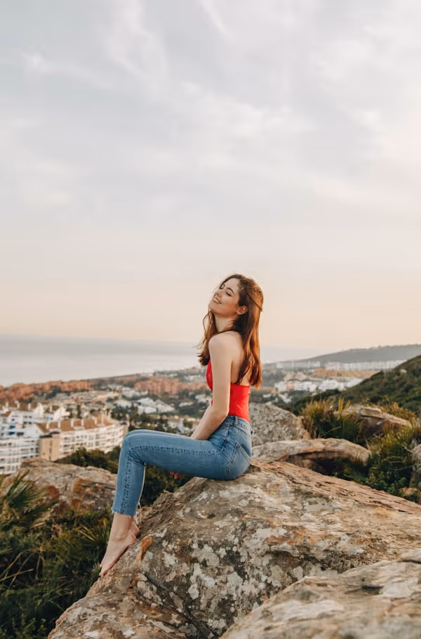 woman sitting on rock during daytime