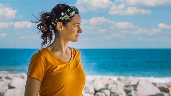 A woman at the beach looking out towards the waves in North Carolina.