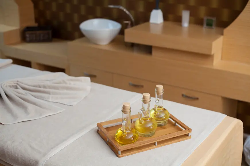 Tray with three massage oil bottles on a spa table, illustrating a wellness service offered by a hotel.