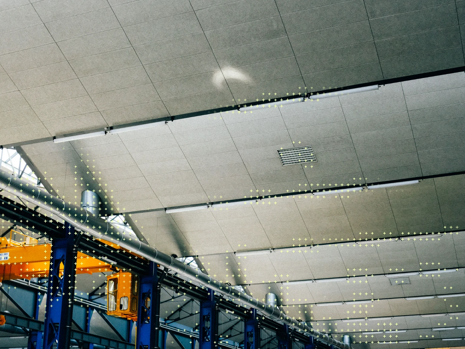 Industrial facility ceiling with overhead crane and steel beams, overlaid with a data-point grid
