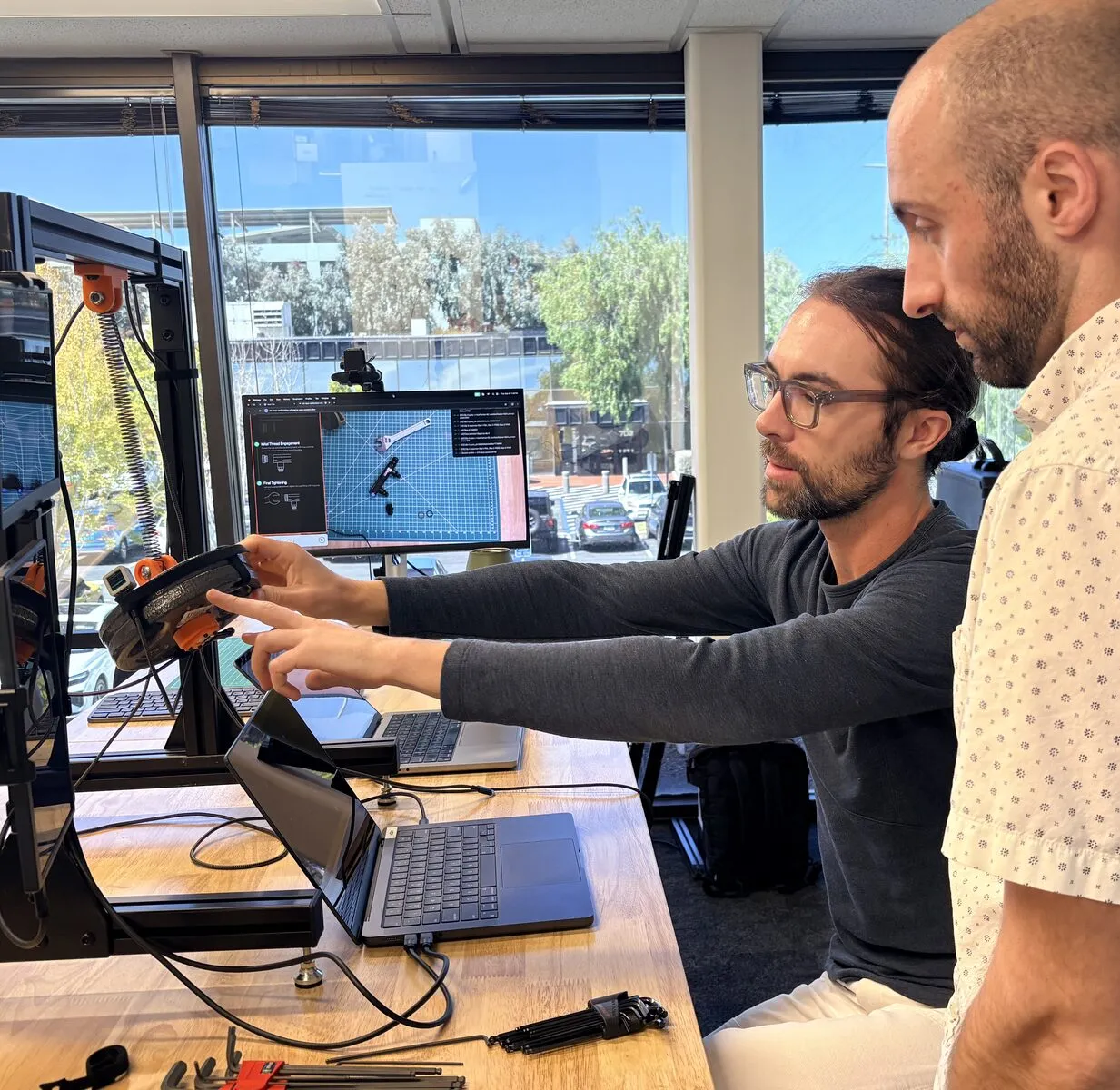 Two Archetype AI engineers reviewing a demo on a monitor