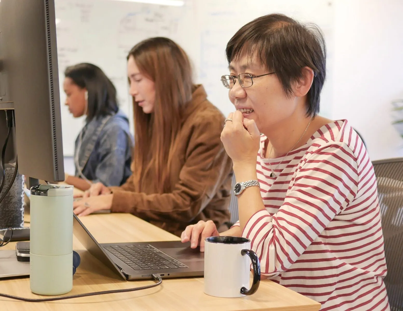 Archetype AI team members working on laptops at a shared desk