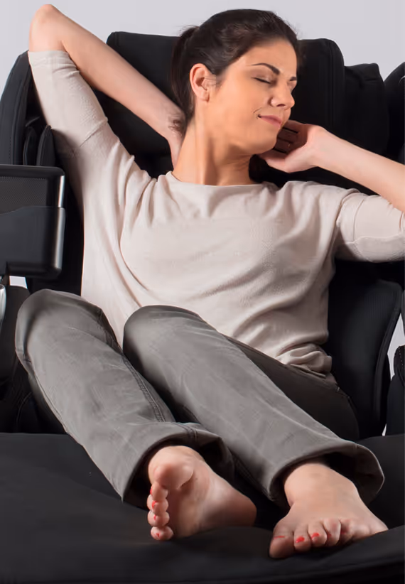 Femme détendue dans le fauteuil massant Evasion 3D de Supra France, fauteuil noir équipé de la technologie de massage 3D pour un confort total du dos et des jambes